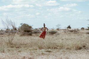 Person in traditional clothing standing in a savannah landscape in Kenya.